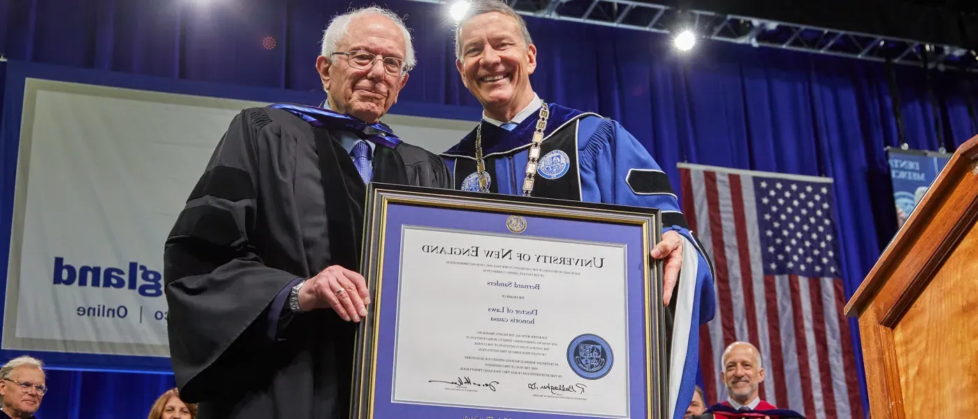 President James D. Herbert hands Sen. Bernie Sanders his honorary degree at 2024 University of New England commencement